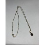 A 9 CARAT GOLD NECKLACE WITH A DARK STONE PENDANT