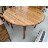 A CIRCULAR PINE DINING TABLE WITH EXTRA LEAF