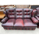 AN OXBLOOD LEATHER THREE SEATER SOFA WITH BUTTONED BACK AND ARMS