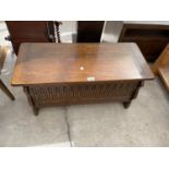 A REPRODUCTION OAK BLANKET CHEST, 31" WIDE WITH CARVED PANEL FRONT