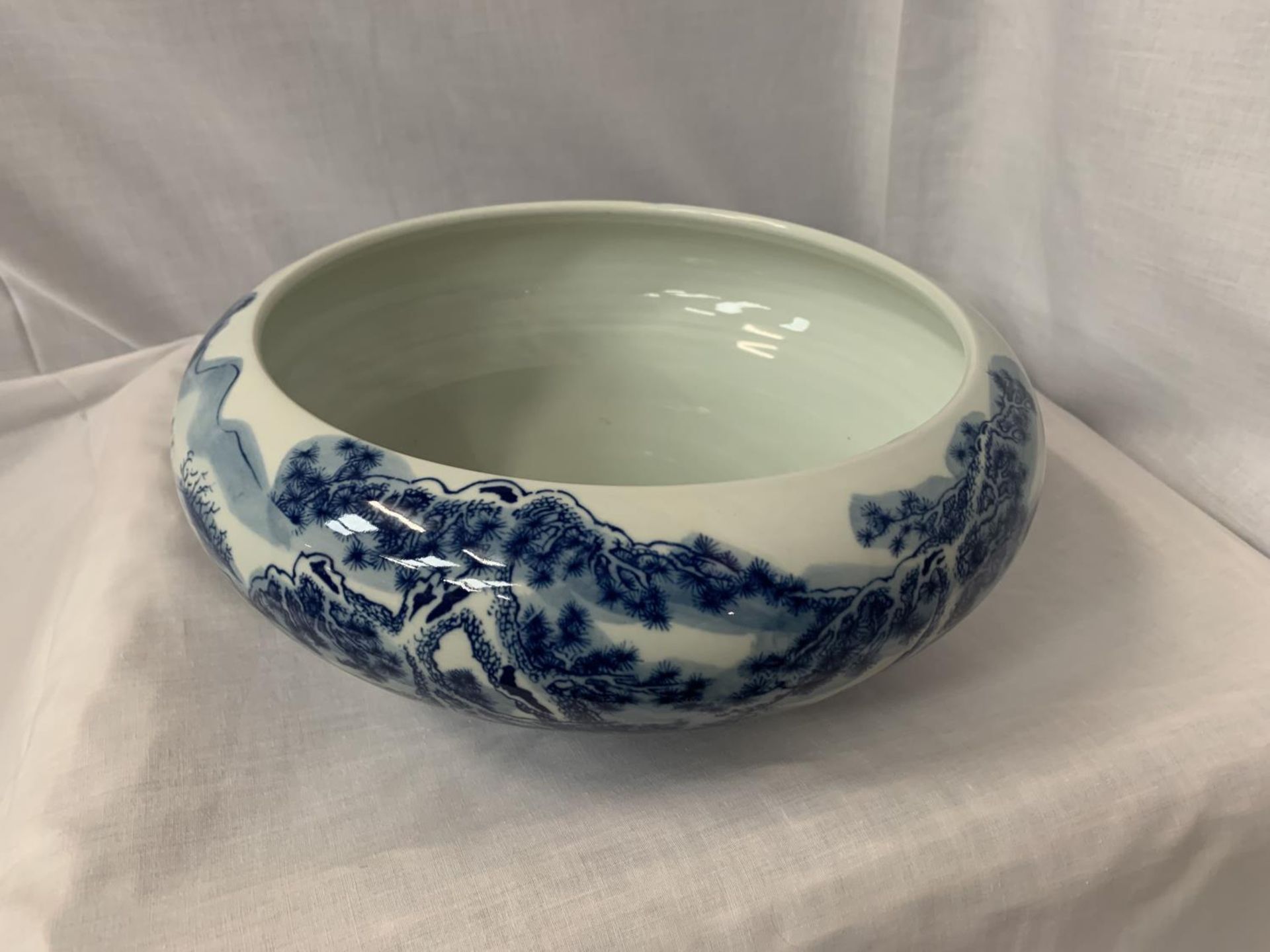 A LARGE HEAVY BLUE AND WHITE CERAMIC BOWL WITH ORIENTAL DECORATION DIA: 32CM