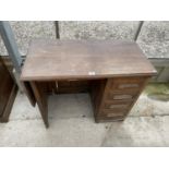 AN EARLY 20TH CENTURY OAK SINGLE PEDESTAL TYPISTS DESK WITH DROP-LEAF BEARING WITHY GROVE STORES