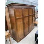 AN EARLY 20TH CENTURY WARING & GILLOW BOWFRONT FOUR DOOR WARDROBE WITH MIRRORED INTERNAL DOOR AND