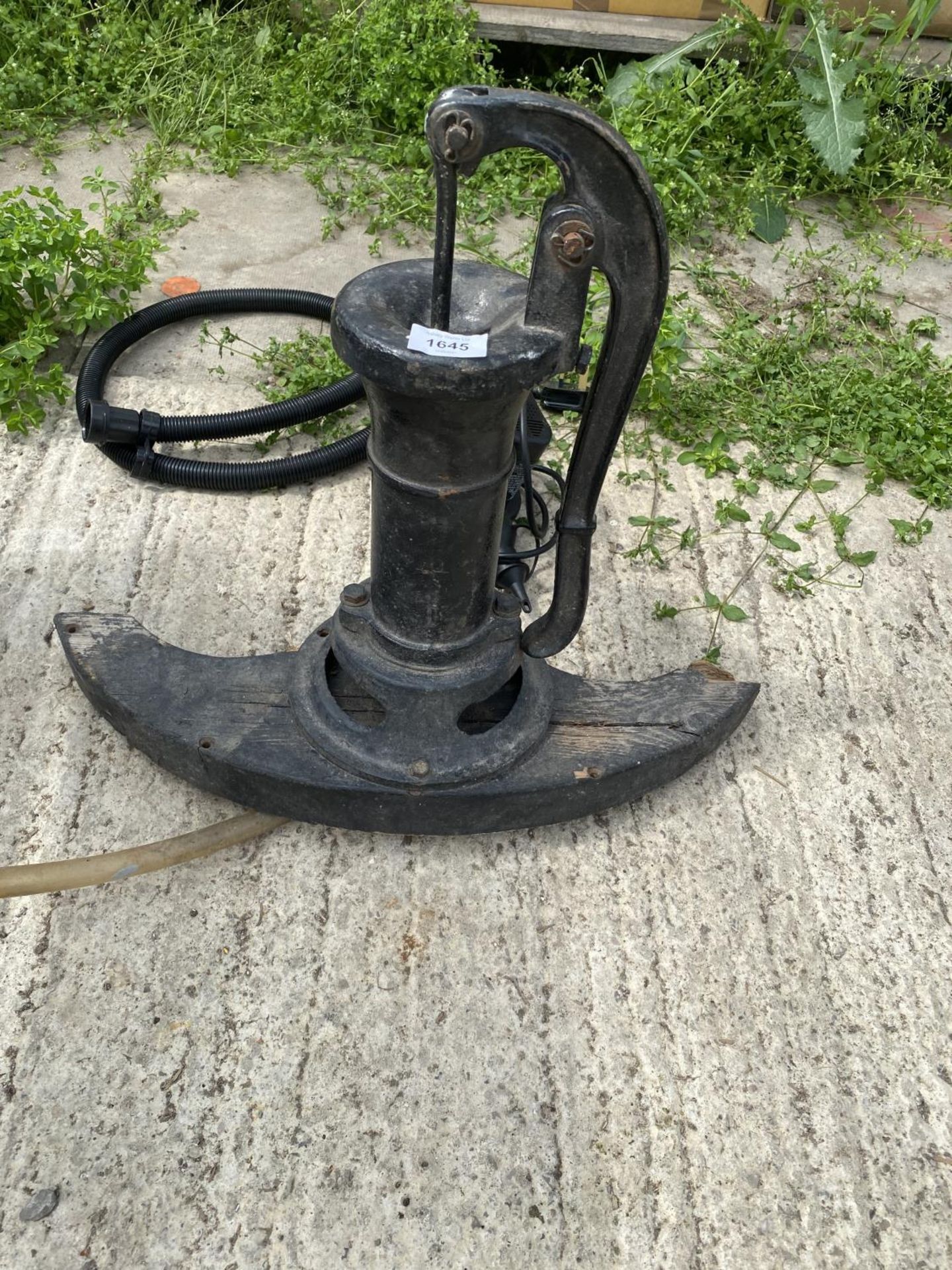 A CAST WATER PUMP CONVERTED WITH PUMP INTO A WATER FEATURE