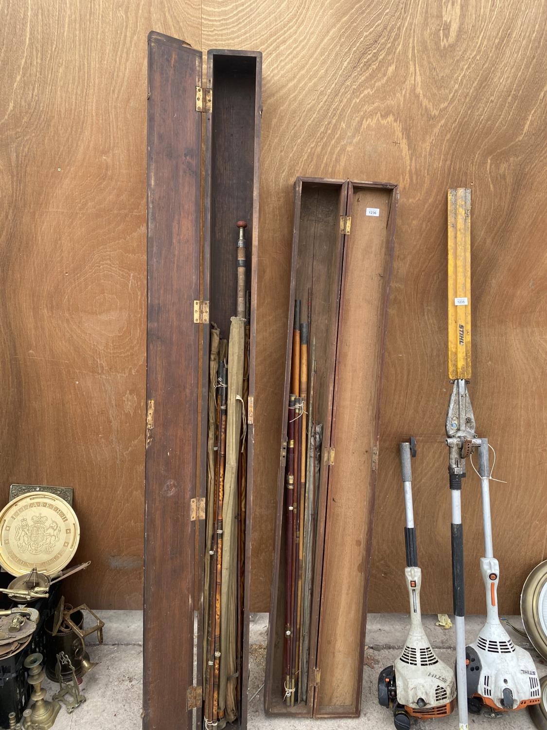 TWO VINTAGE WOODEN STORAGE CASES WITH AN ASSORTMENT OF FISHING RODS TO INCLUDE SPLIT CANES ETC