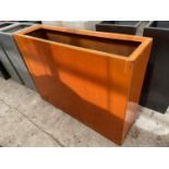 A RECTANGULAR ORANGE FIBRE GLASS PLANTER (H:90CM W:120CM)