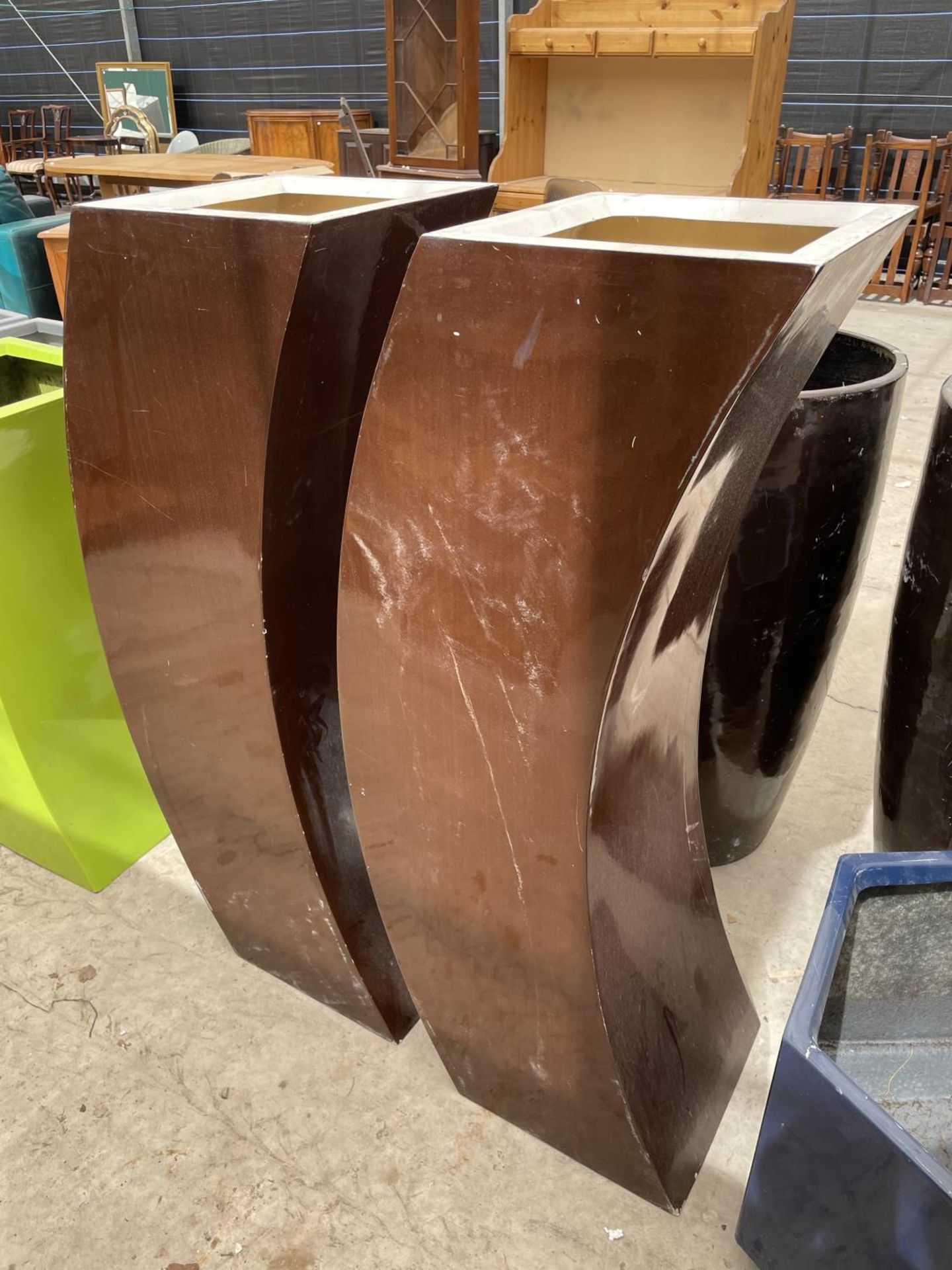 A PAIR OF DECORATIVE BROWN CURVED FIBRE GLASS PLANTERS (H:120CM)