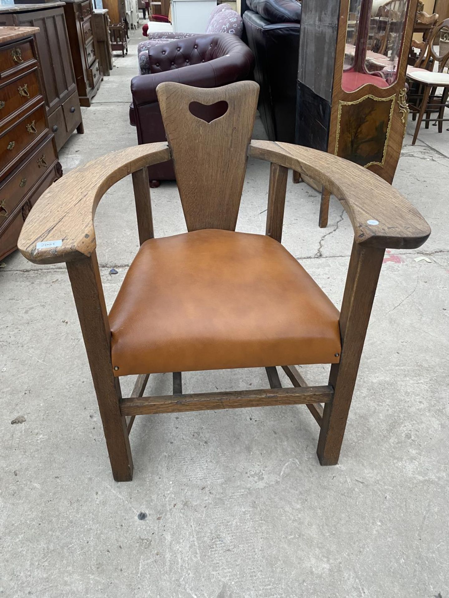 AN OAK ART NOUVEAU TUB CHAIR WITH PLATEAU ARMS AND HEART CARVING TO THE BACK, COMPLETE WITH