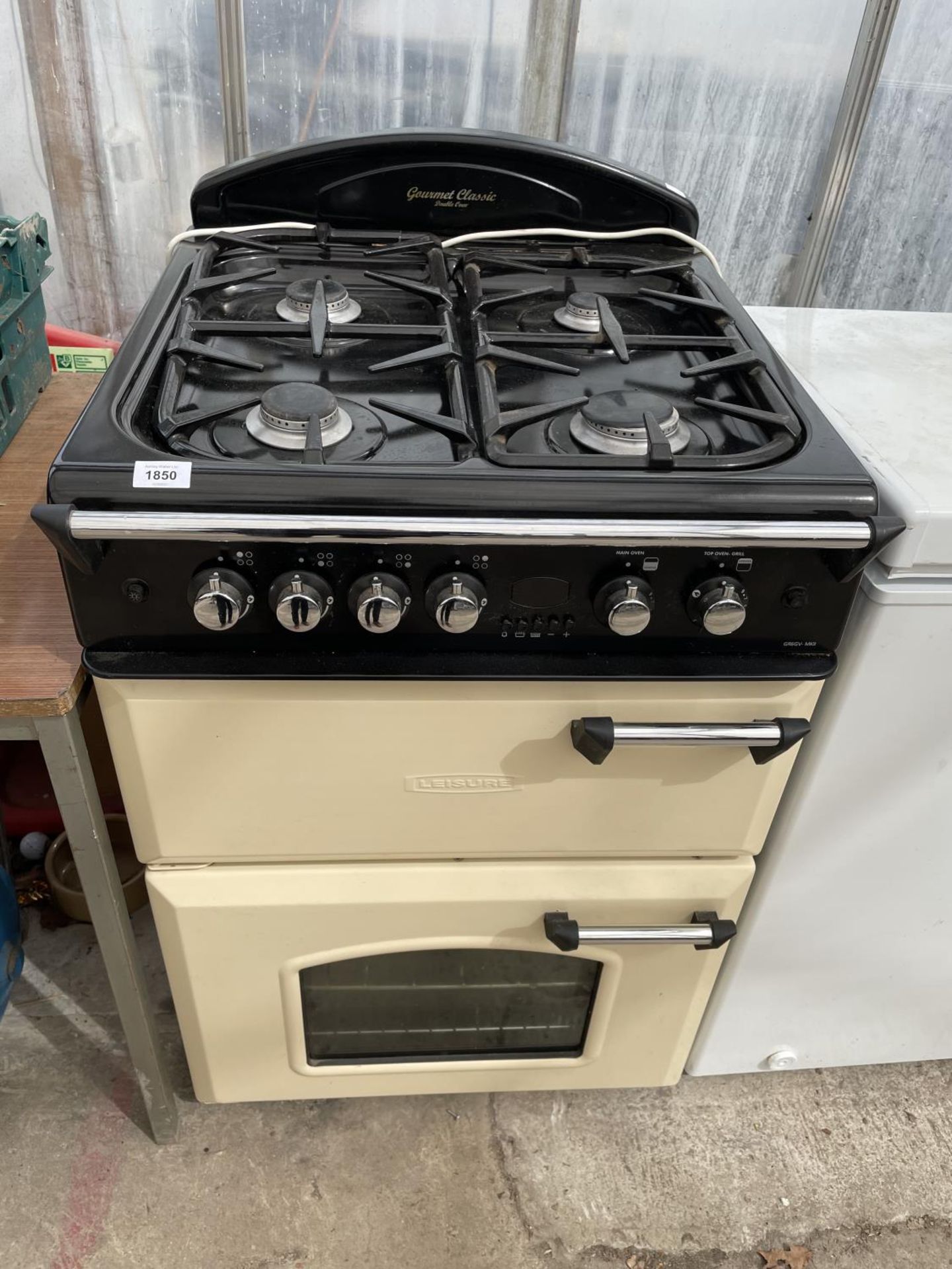 A CREAM AND BLACK LEISURE FREE STANDING COOKER AND HOB BELIEVED WORKING BUT NO WARRANTY