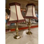 A PAIR OF BRASS TABLE LAMPS WITH ORNATE CREAM, RED AND GOLD FABRIC LAMP SHADES WITH GOLD THREAD