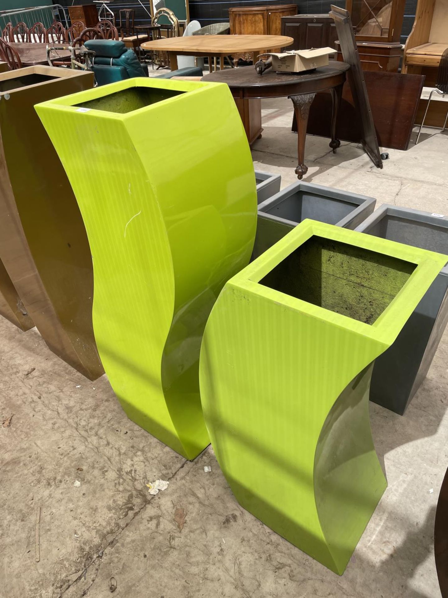 TWO CURVED GREEN FIBRE GLASS PALNTERS (H:120CM AND H:90CM)