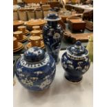 A TRIO OF BLUE AND WHITE LIDDED JARS IN THE ORIENTAL CHERRY BLOSSOM DESIGN H: 19CM, 21CM AND 31CM