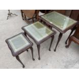 A MAHOGANY NEST OF THREE TABLES WITH GREEN LEATHER AND GLASS TOPS