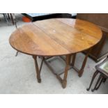 AN OVAL OAK DROP LEAF DINING TABLE ON TURNED SUPPORTS - 42" X 53.5"