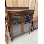 AN EARLY 20TH CENTURY OAK GLAZED AND LEADED TWO DOOR BOOKCASE ON CABRIOLE LEGS W:36"