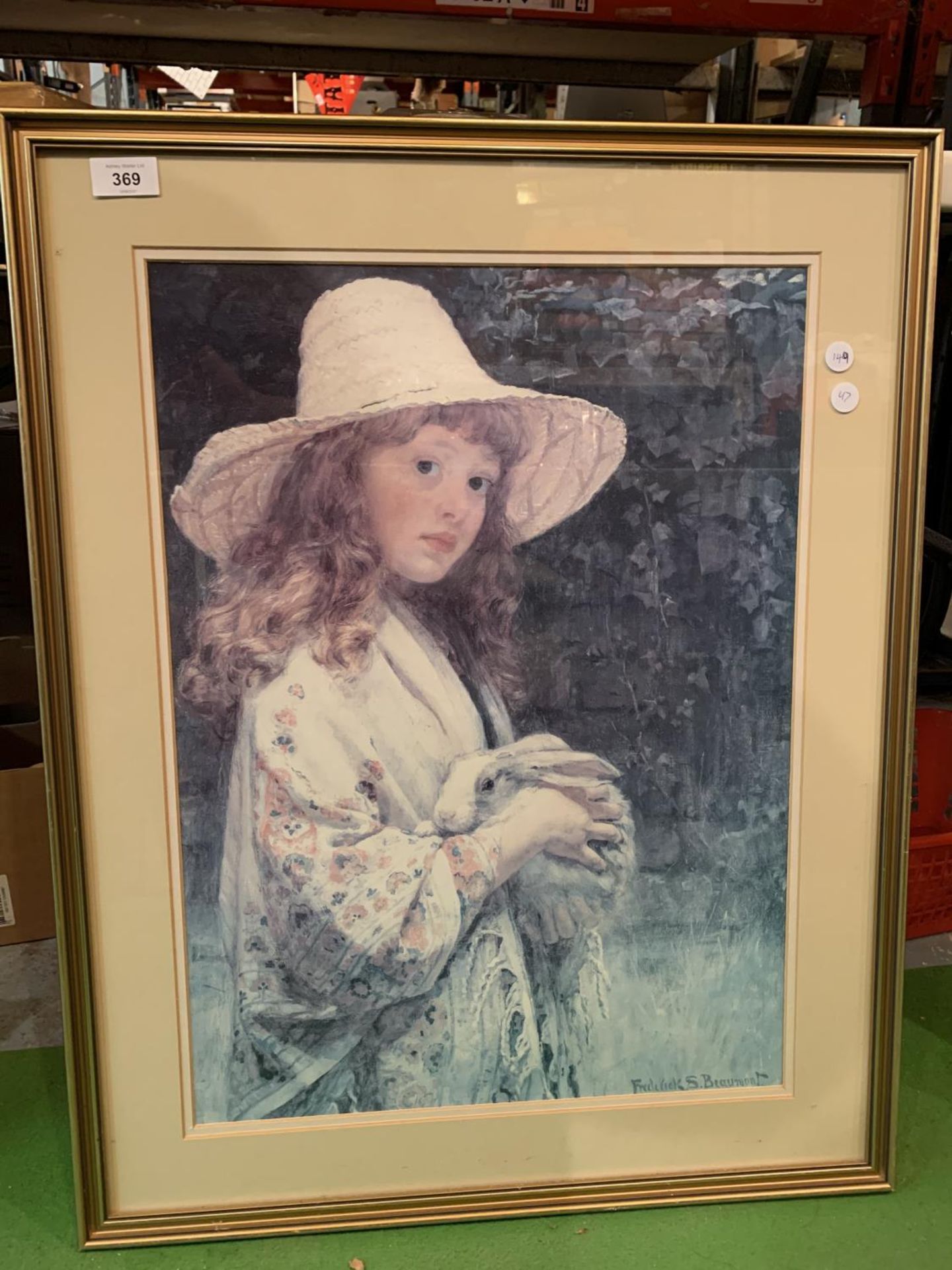 A GILT FRAMED PICTURE DEPICTING A GIRL HOLDING A RABBIT