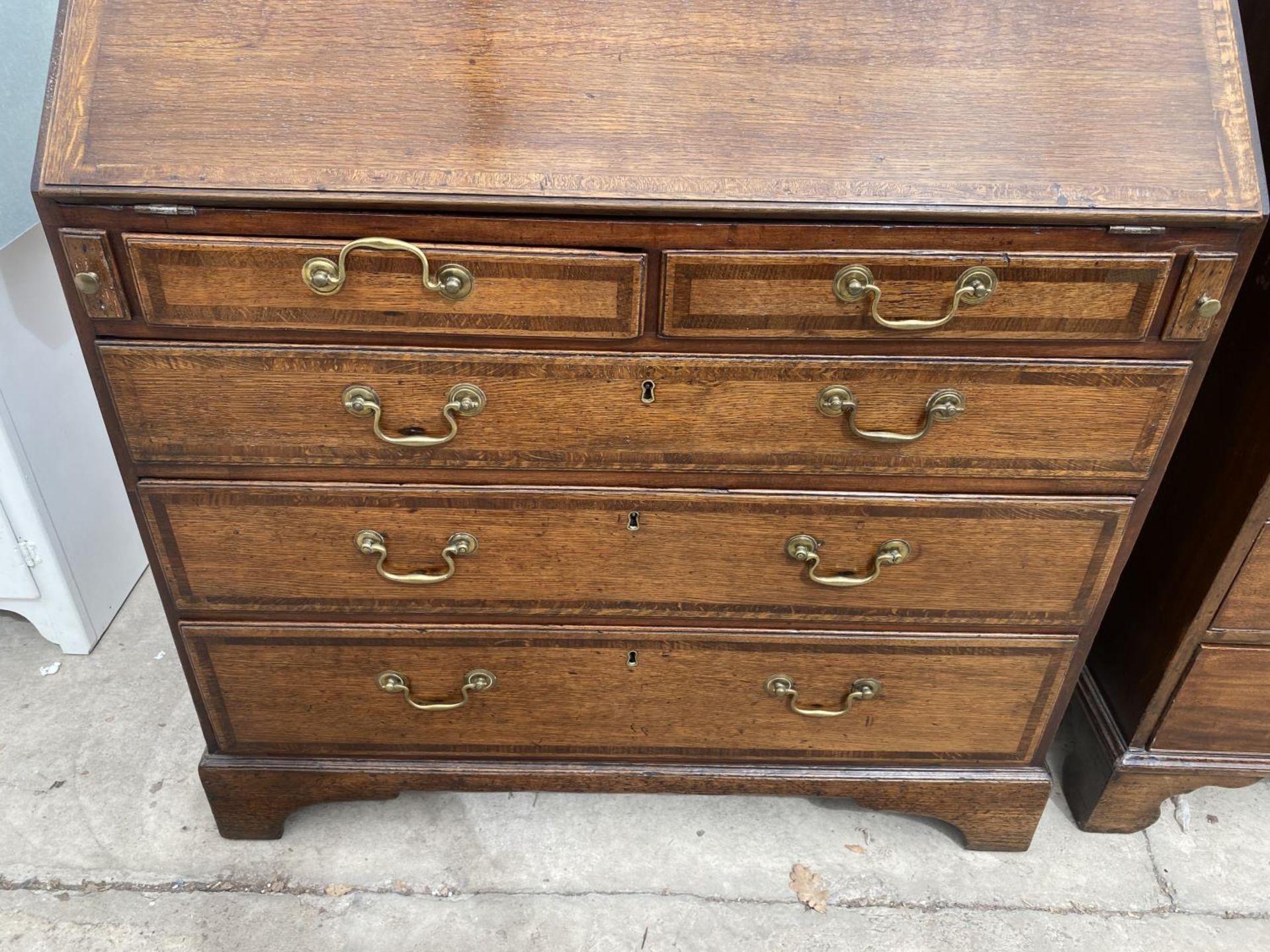 A GEORGE III OAK AND CROSSBANDED BUREAU WITH TWO SHORT AND THREE GRADUATED DRAWERS ON BRACKET FEET - Image 2 of 3