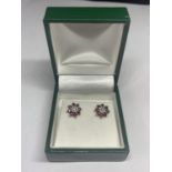 A PAIR OF 9 CARAT GOLD EARRINGS IN A FLOWER DESIGN WITH RED AND CLEAR STONES IN A PRESENTATION BOX