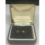 A PAIR OF 9 CARAT GOLD EARRINGS WITH A DARK STONE IN A PRESENTATION BOX