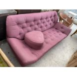 A 1970'S STYLE BUTTON BACK SETTEE WITH LOW RAKING ARMS AND MATCHING POUFFE