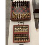 TWO ORIENTAL CHESS SETS ONE OF WHICH IS A SMALLER TRAVEL SIZE WITH BRASS HANDLES AND CLASP DETAIL.