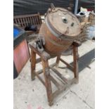 A VINTAGE WOODEN BUTTER CHURN ON A STAND