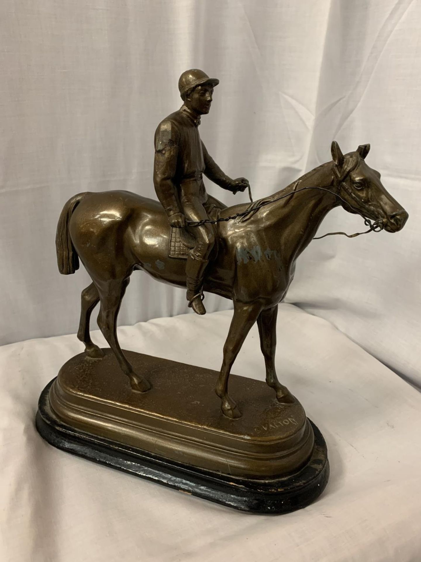 A SPELTER FIGURINE IN THE FORM OF A HORSE AND JOCKEY SIGNED C VALTON