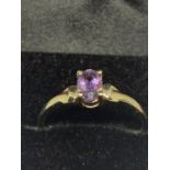 A 9 CARAT GOLD RING WITH AN AMETHYST SIZE M IN A HEART SAHPED PRESENTAION BOX