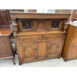 AN OAK COURT CUPBOARD WITH TWO DOORS, TWO DRAWERS AND TWO UPPER LEAD GLAZED DRAWERS AND BALUSTER