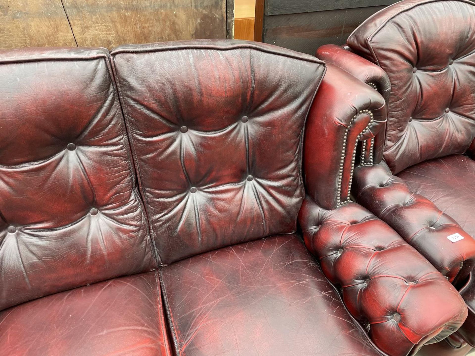 AN OXBLOOD LEATHER THREE SEATER SOFA WITH BUTTONED BACK AND ARMS - Image 3 of 6