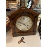 A VINTAGE MANTLE CLOCK WITH KEY AND PENDALUM
