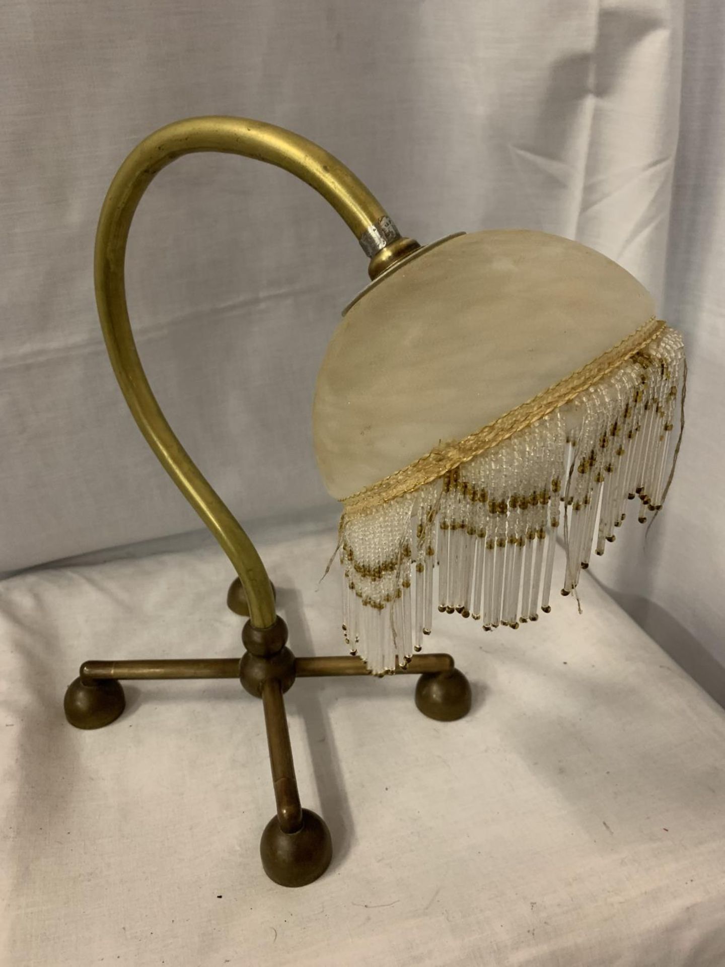 A BENSON BRASS TABLE LAMP WITH DECO GLASS SHADE AND FRINGE