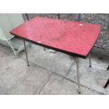 A 1950'S KITCHEN TABLE, 41.5X23.5" WITH RED, BLACK AND GOLD COLOURED TOP, ON TUBULAR METAL FRAME
