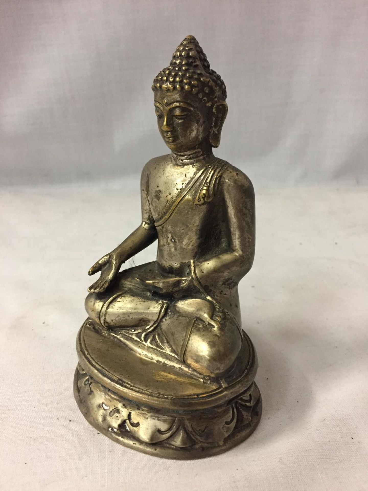 A SILVER PLATED ASIAN SITTING BUDDAH