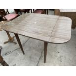 A 1950'S CREAMY WALNUT EFFECT DROP-LEAF DINING TABLE ON TAPERED LEGS