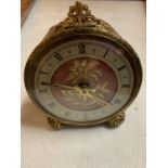 A VINTAGE ORNATE GILT ALARM CLOCK WITH EMBRIODERED FACE