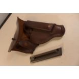 A BROWN LEATHER HOLSTER AND MAGAZINE