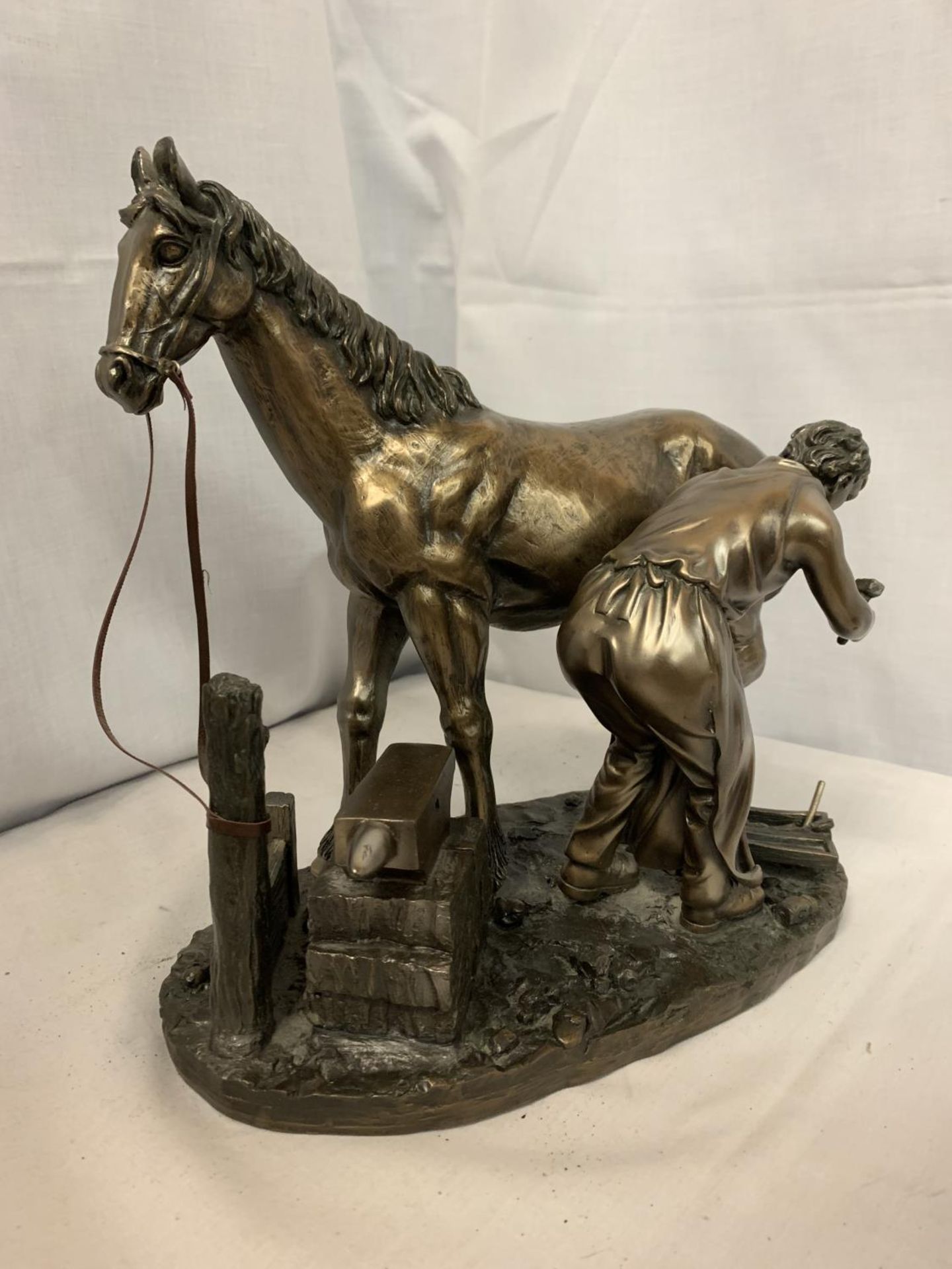 A FIGURE OF A BLACKSMITH SHOEING A HORSE H: 27.5CM