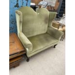 A QUEEN ANNE STYLE WINGED SETTEE WITH DOUBLE ARCHED BACK, ON FRONT CABRIOLE LEGS