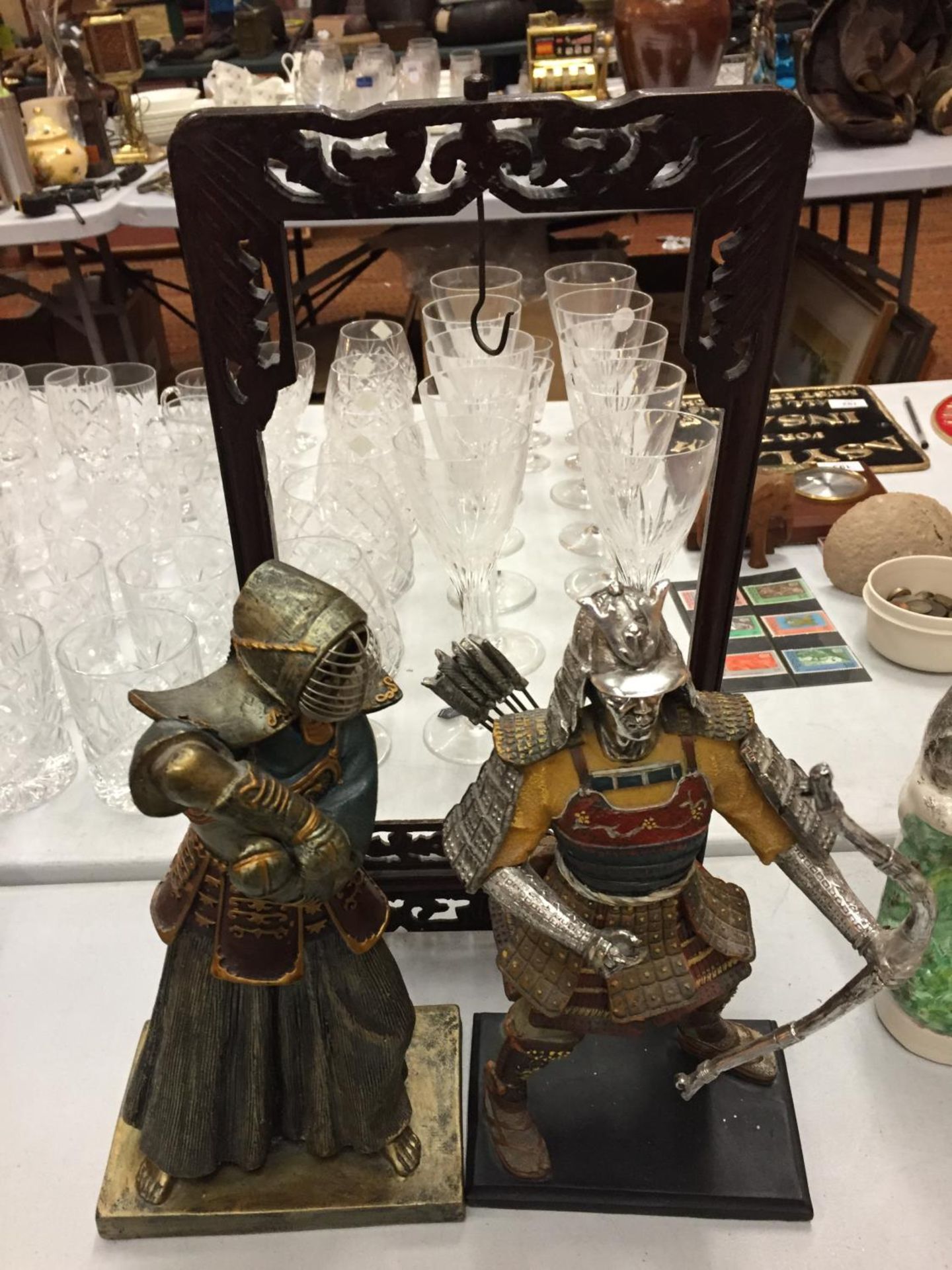 AN ORNATE CARVED WOODEN GONG HOLDER AND TWO WARRIOR FIGURINES