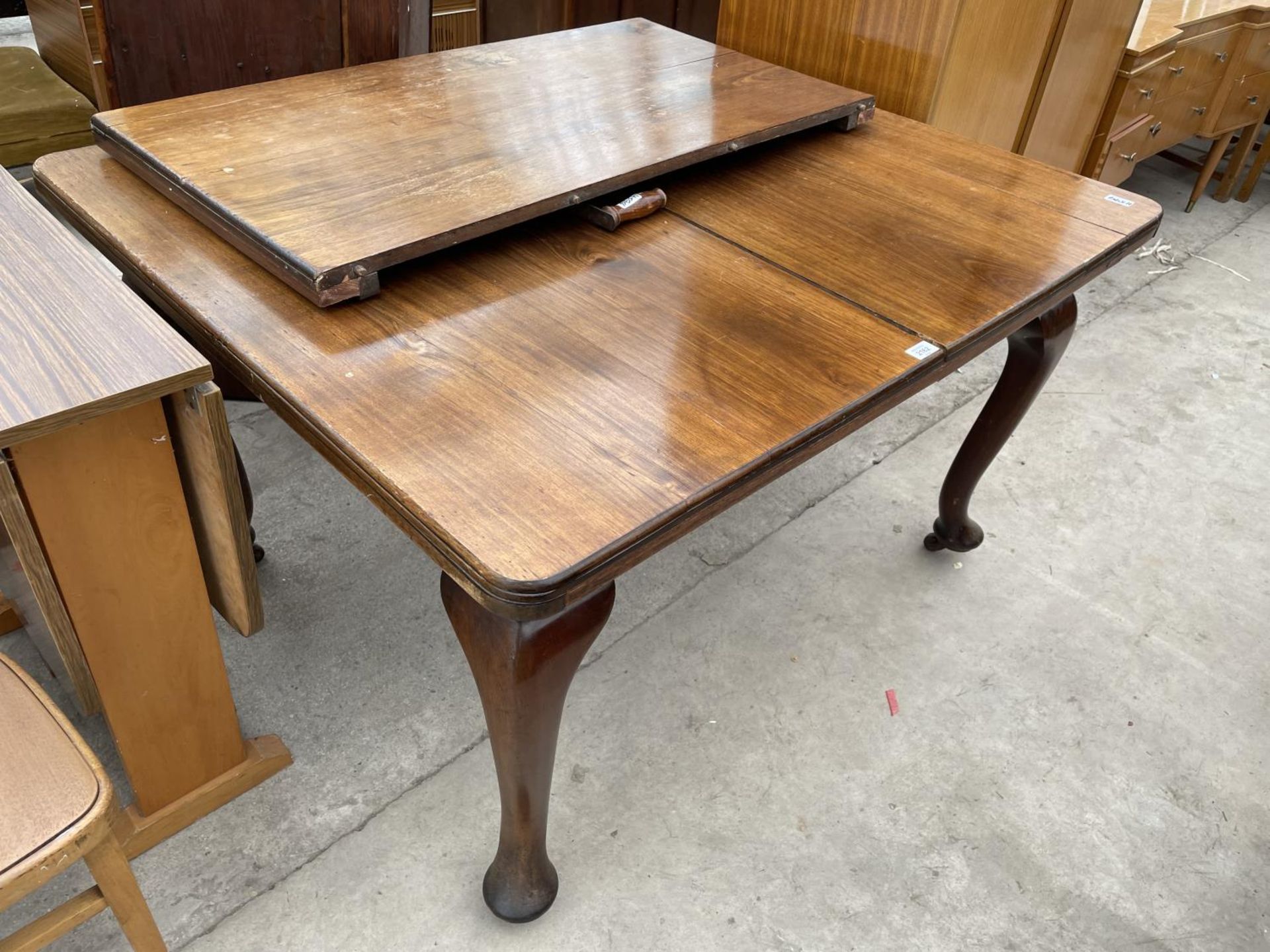 AN EDWARDIAN MAHOGANY WIND-OUT DINING TABLE ON CABRIOLE LEGS WITH EXTRA LEAF AND WINDER, 49X41" (