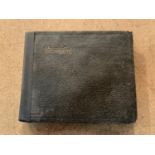 A SMALL VINTAGE PHOTO ALBUM CONTAINING BLACK AND WHITE IMAGES