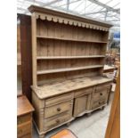 A VICTORIAN PINE KITCHEN DRESSER ENCLOSING SEVEN DRAWERS TO THE BASE AND CENTRAL CUPBOARDS, HAVING