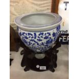 A CHINESE ORIENTAL BLUE AND WHITE JARDINERE BOWL ON A WOODEN STAND