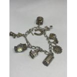 A SILVER CHARM BRACELET WITH TEN VARIOUS CHARMS TO INCLUDE A HORSES HEAD, HORSESHOE, CROWN ETC