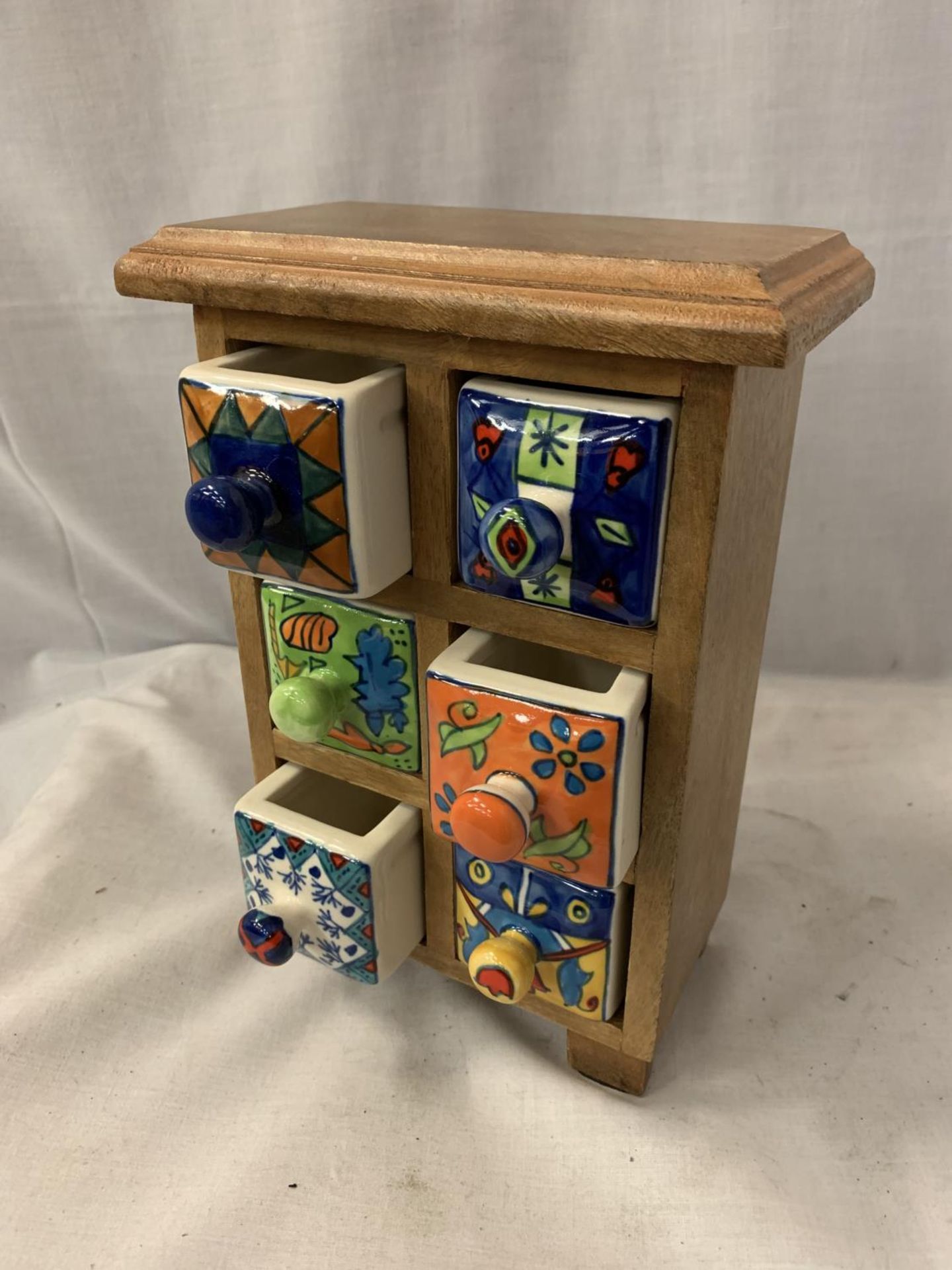 A JEWELLERY BOX WITH SIX BRIGHTLY COLOURED CERAMIC DRAWERS