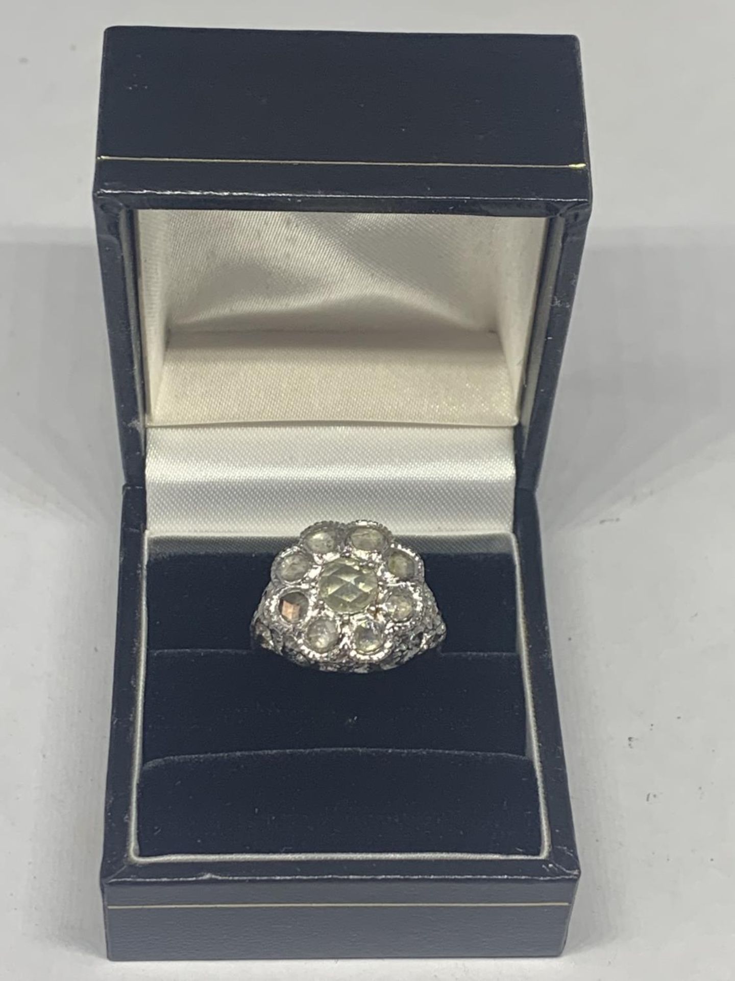 AN 18 CARAT WHITE GOLD DIAMOND CLUSTER RING WITH A CENTRE AND EIGHT SURROUNDING DIAMONDS GROSS