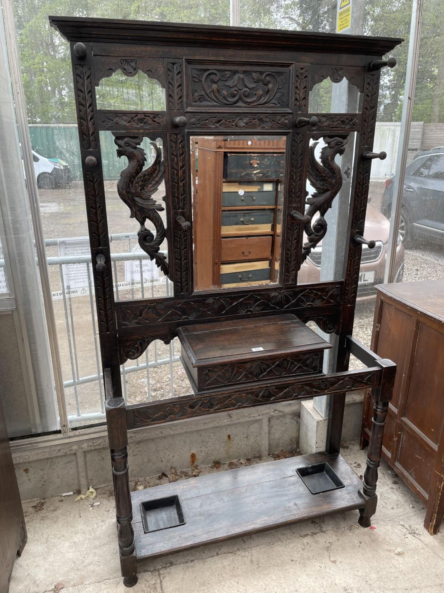 A VICTORIAN HEAVILY CARVED OAK MIRRORED HALL COAT/STICK STAND WITH MIRRORED BACK - 42" WIDE