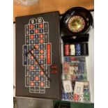 A ROULETTE BOARD WITH WHEEL, CHIPS, DICE ETC