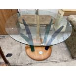 A MODERNIST CIRCULAR GLASS TOP TABLE SUPPORTED BY SIX COLOURED TUSK SHAPED LEGS, ON PLATEAU BASE,